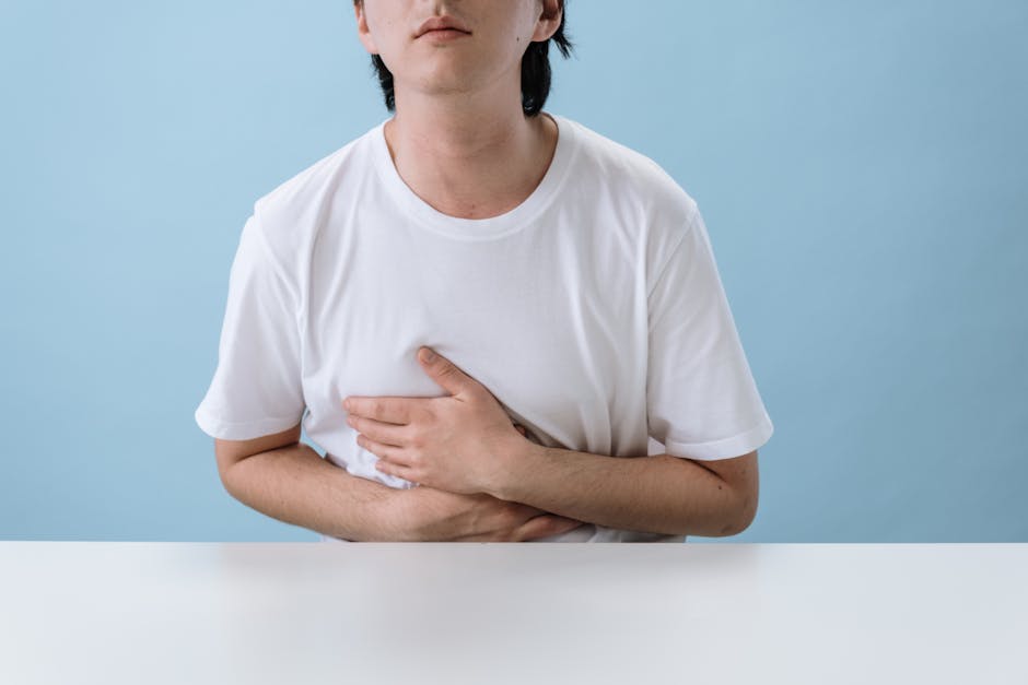 Kronik hazımsızlık yaşayan bir kişinin karın ağrısı hissiyle elini karnına götürdüğü sahne